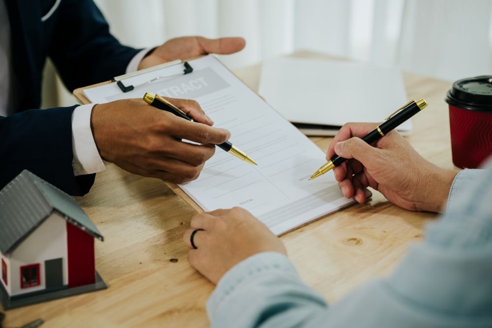 Two people exchanging property contracts